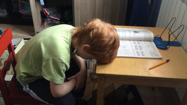 Втомлений хлопчик робить домашнє завдання